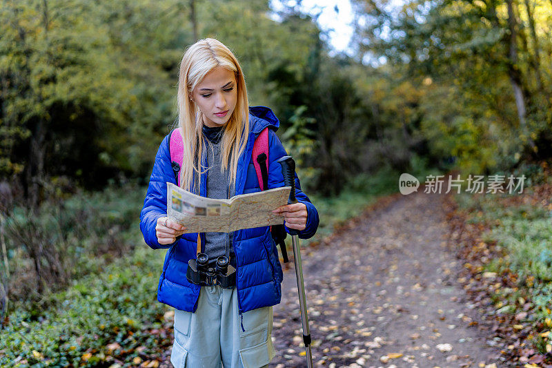 Woman confidently reads map, leading the way on her hike